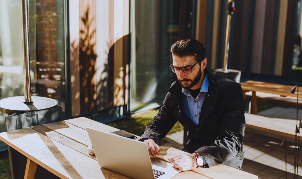 Man at the Table Using Laptop