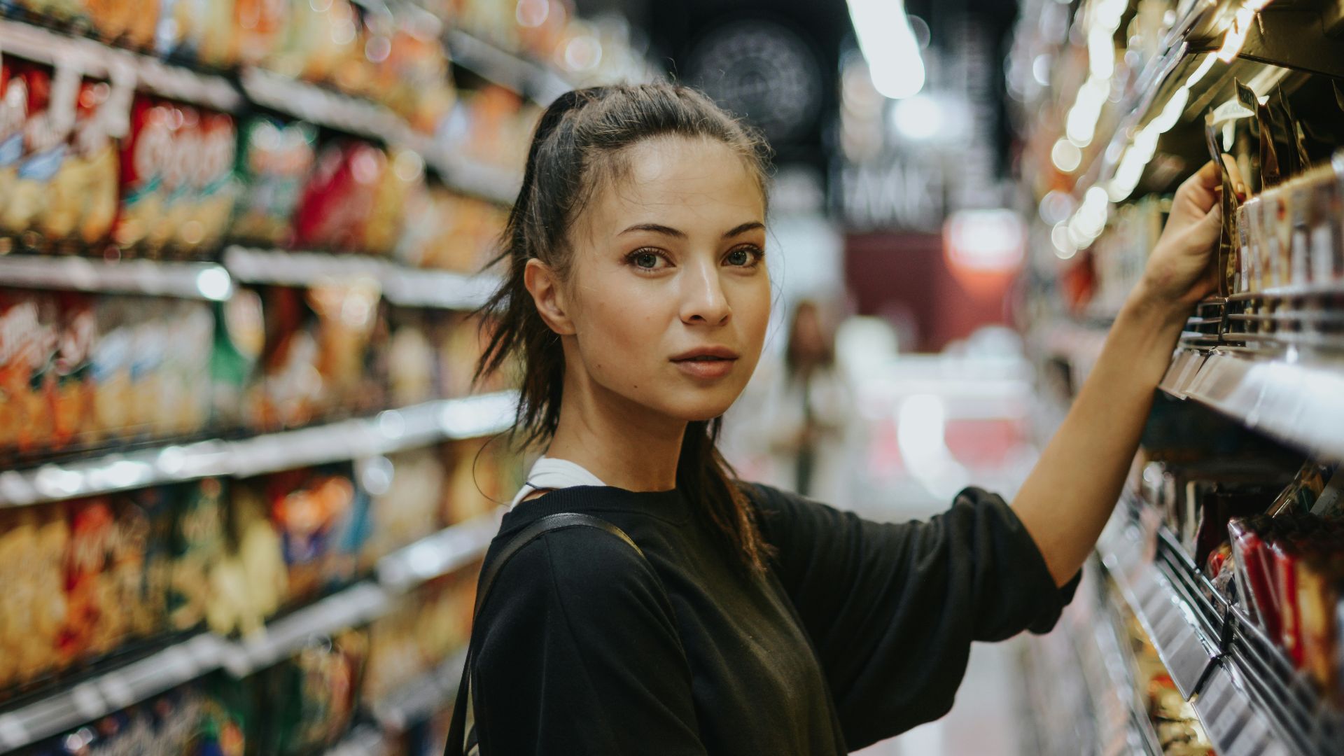 woman selecting packed food on gondola