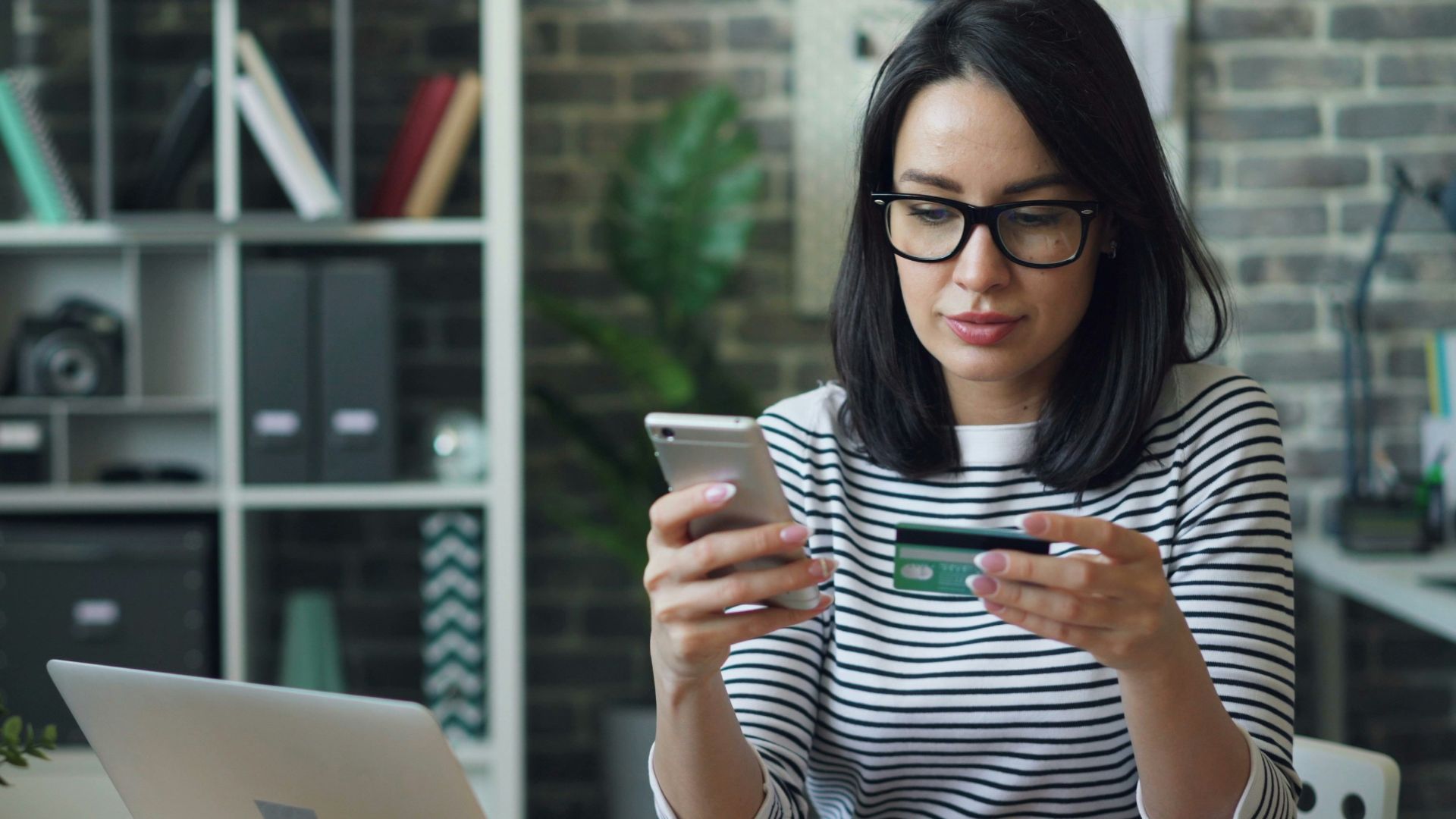 a woman sitting at a table looking at her cell phone