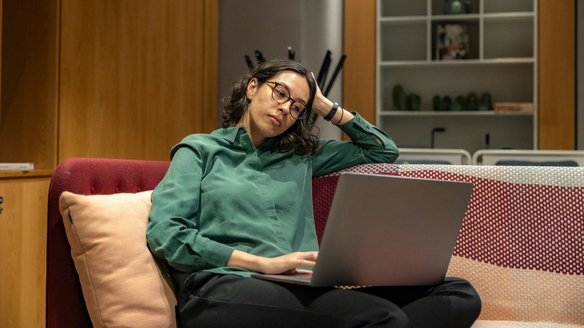 a woman sitting on a couch using a laptop computer