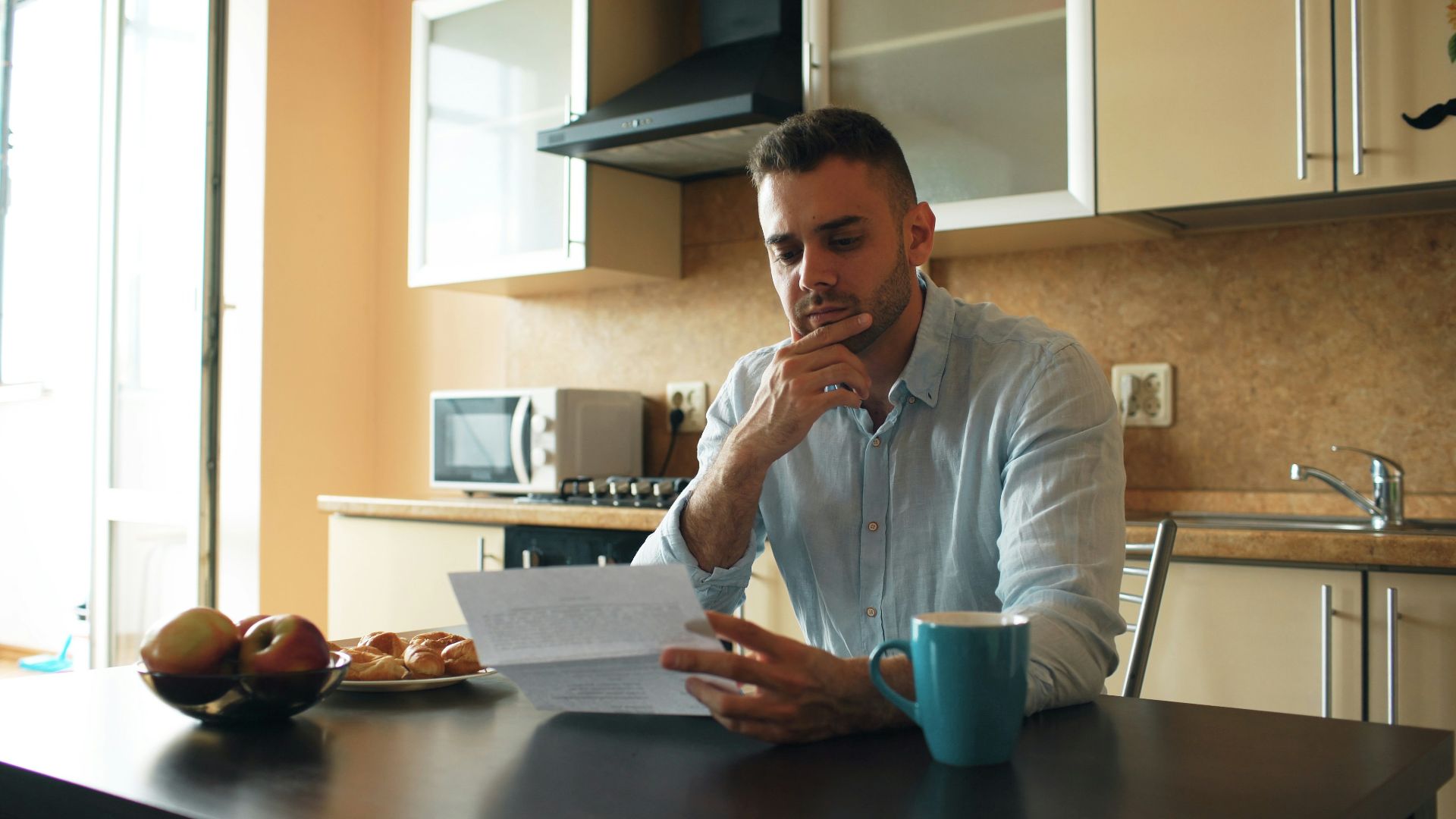 Man reading a document in a kitchen