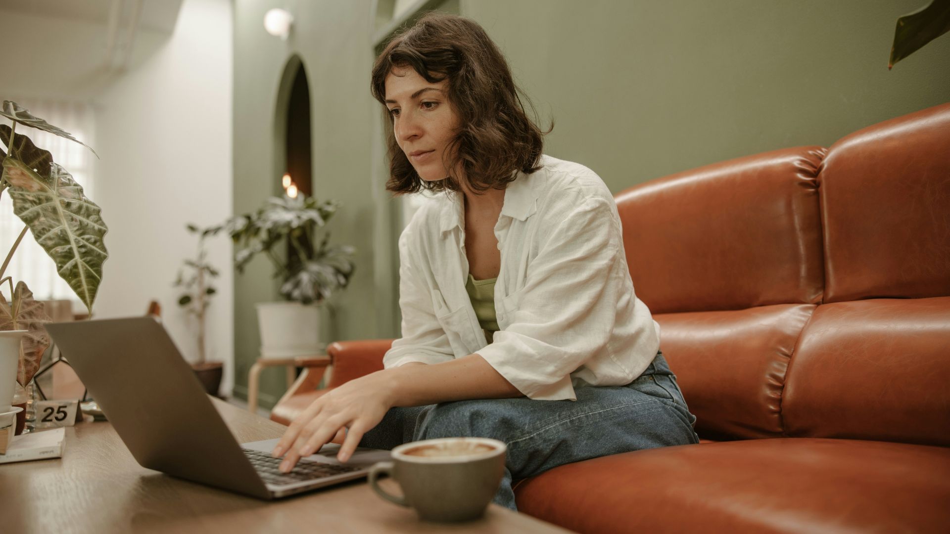 a woman sitting on a couch using a laptop computer