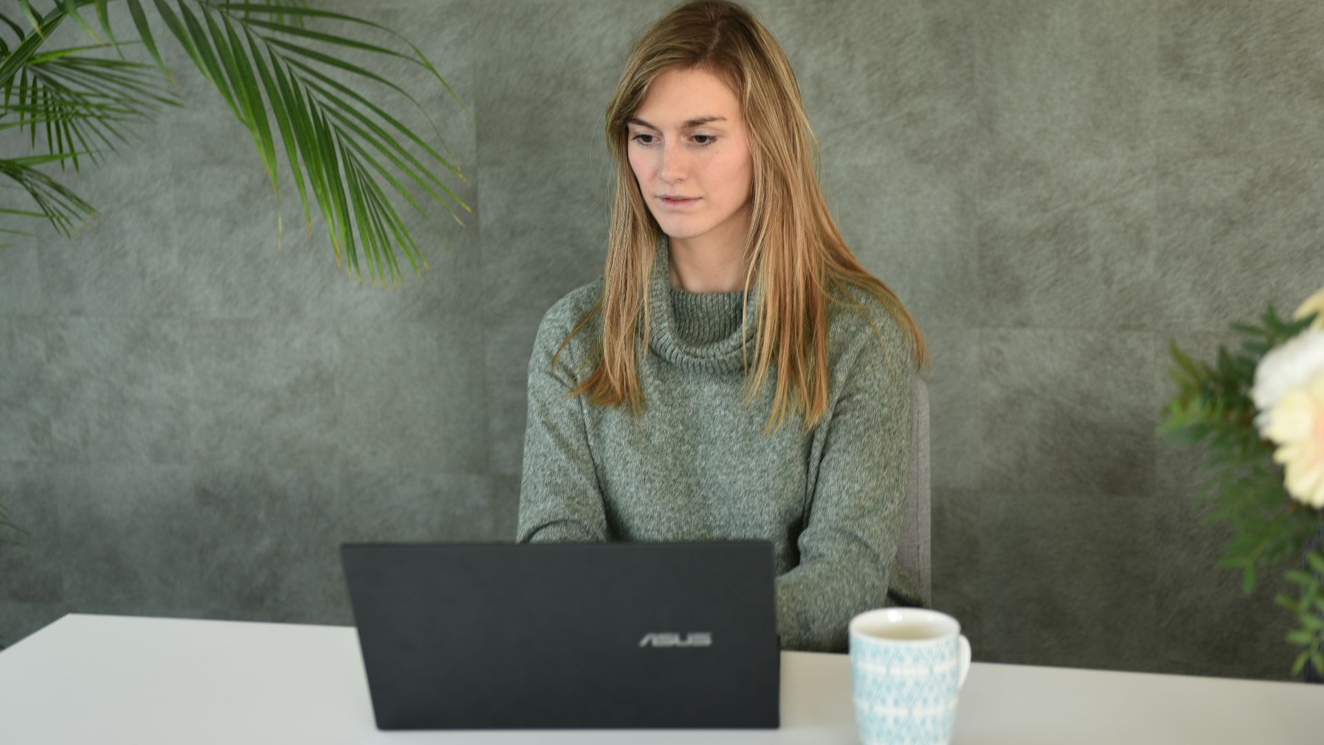 a woman sitting at a table with a laptop