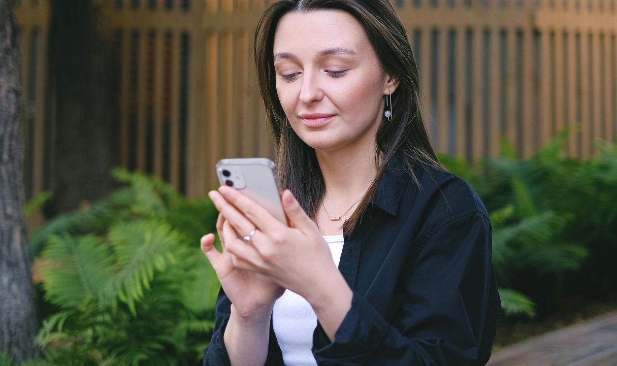 Woman using a Smartphone while Sitting on a Bench