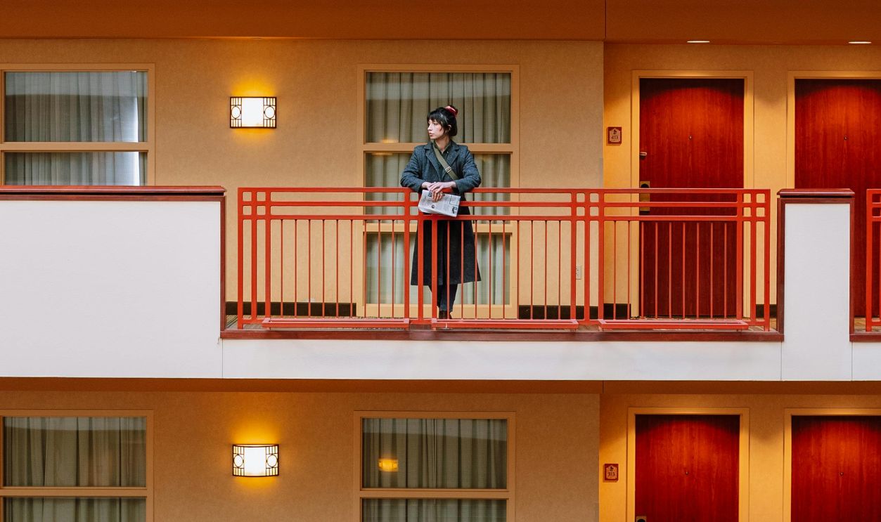 Woman Standing on Balcony