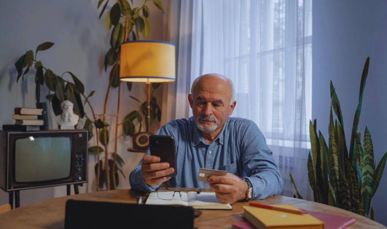 Man Holding Smartphone and a Credit Card