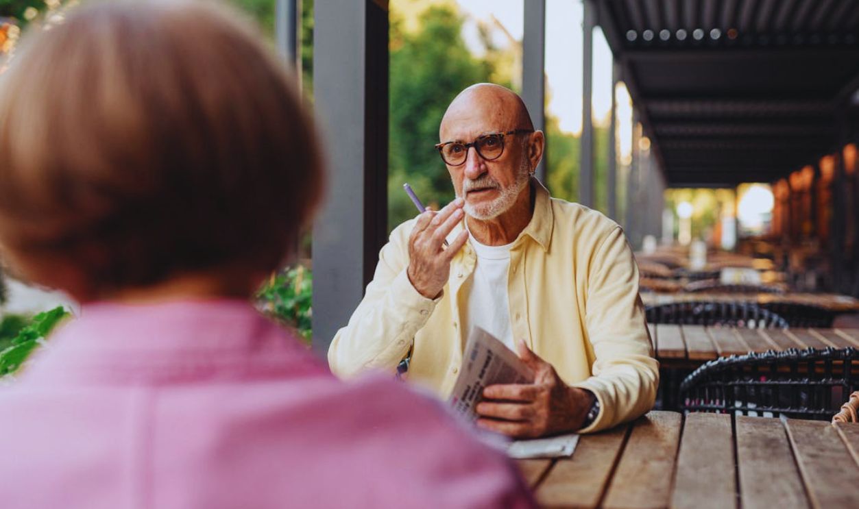 Elderly Couple Talking to Each Other at the Wooden Table