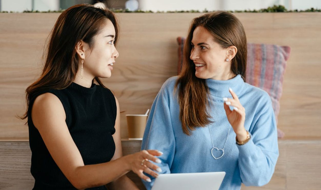 Multiracial businesswomen with laptop talking about work