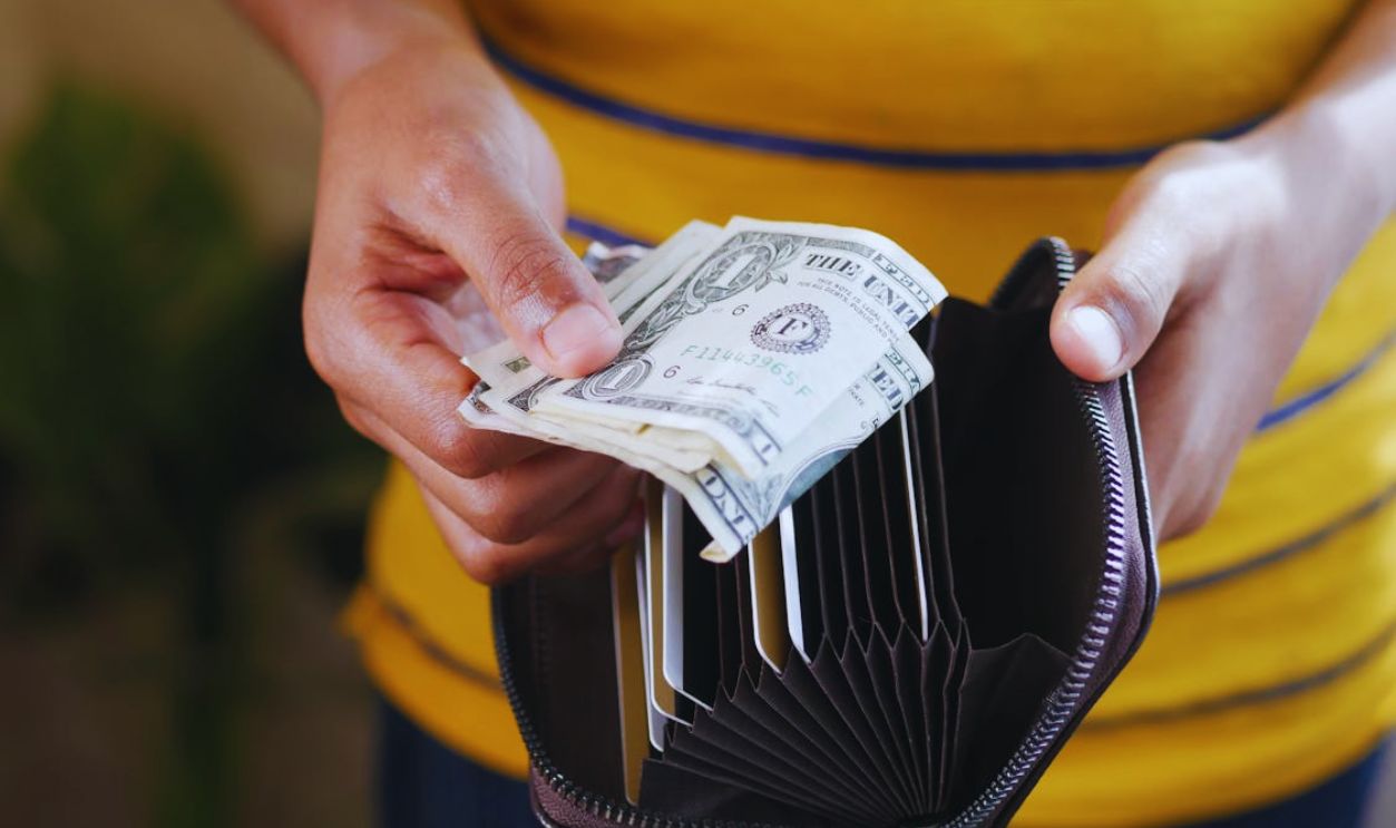 A Person Getting Money in the Wallet