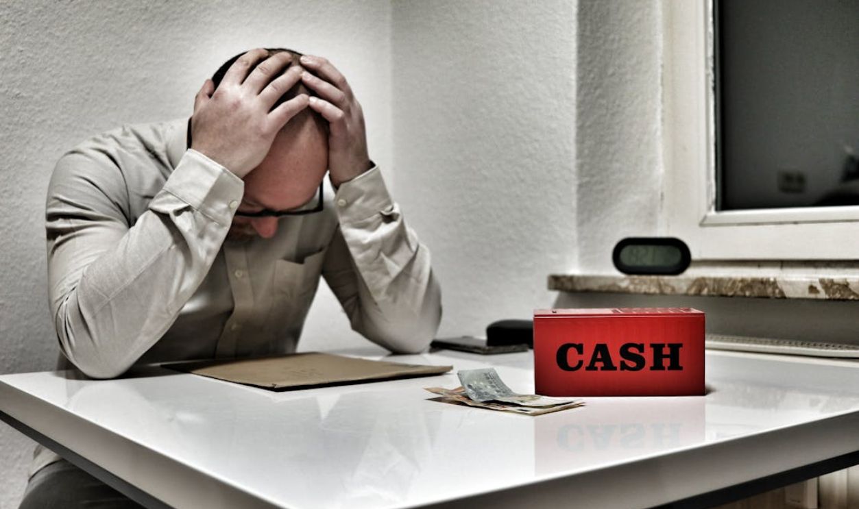 Stressed Man with Cash Box in Office Setting