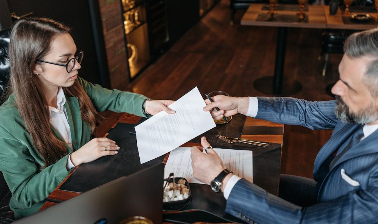 Woman Giving Paper to Man