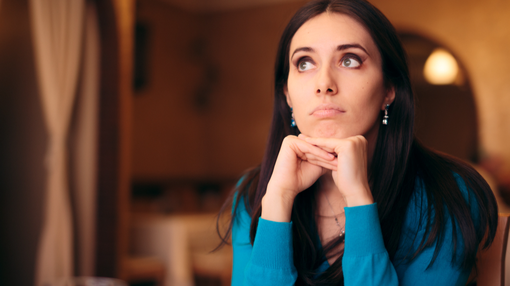 Upset millennial girl in blue top feeling bored at a party or a date