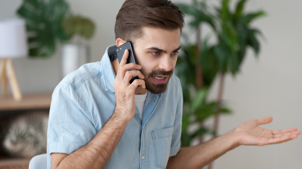 irritated male have cell phone conversation to  manage work trouble