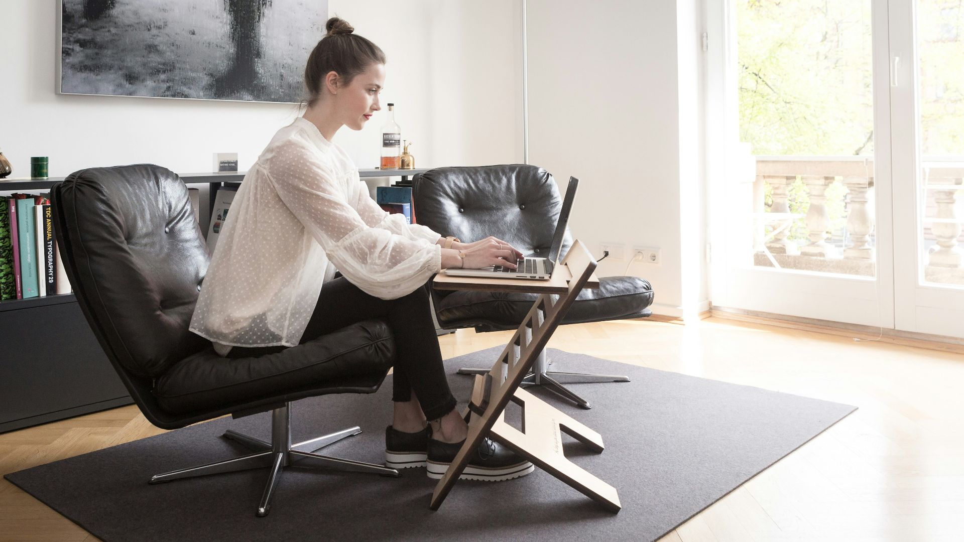 woman in white long sleeve shirt sitting on black leather armchair