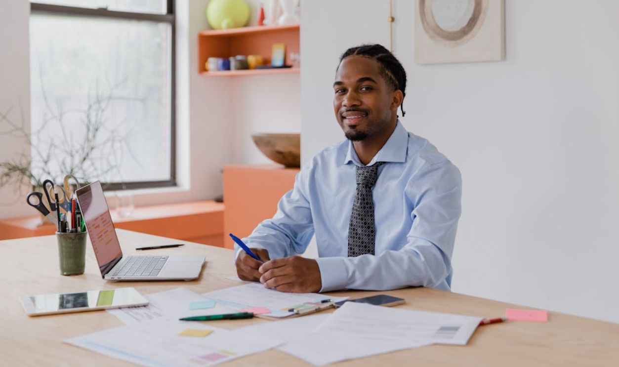 Smiling Man Sitting at his Desk in the Office