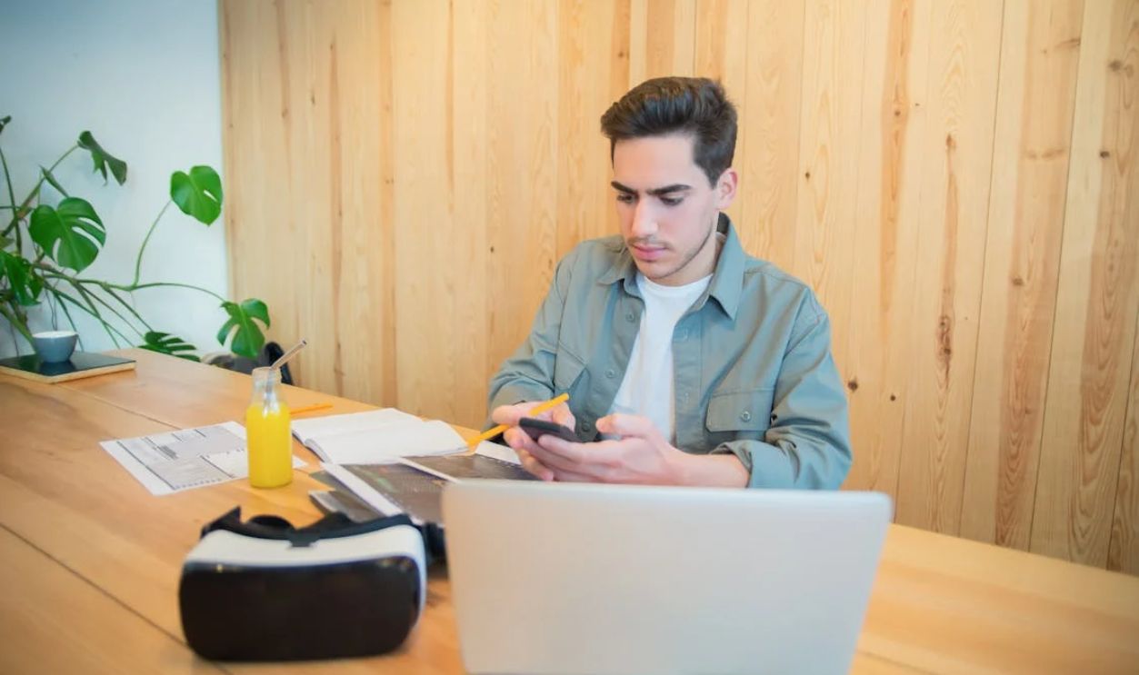 A Man Looking at His Cellphone While Working