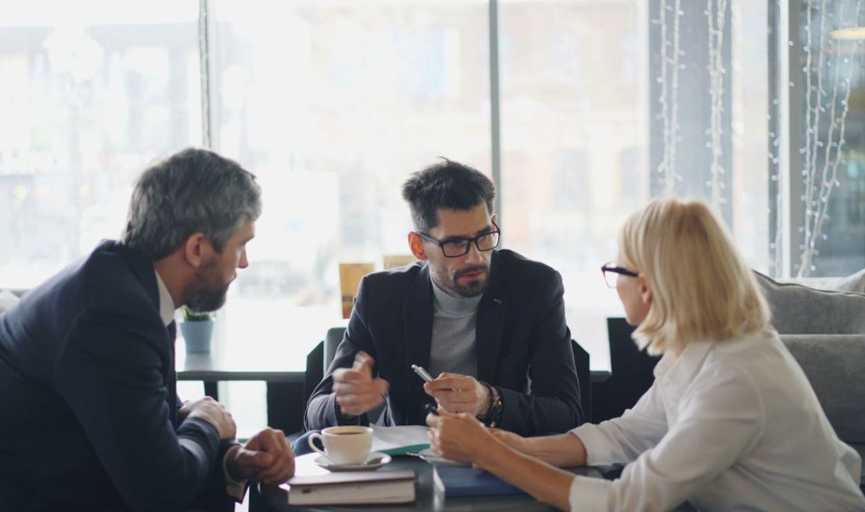 Three business people sitting at a table talking