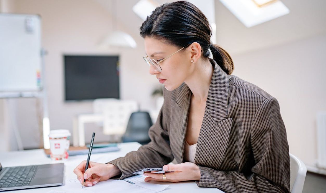 Woman in Brown Coat Writing a Note