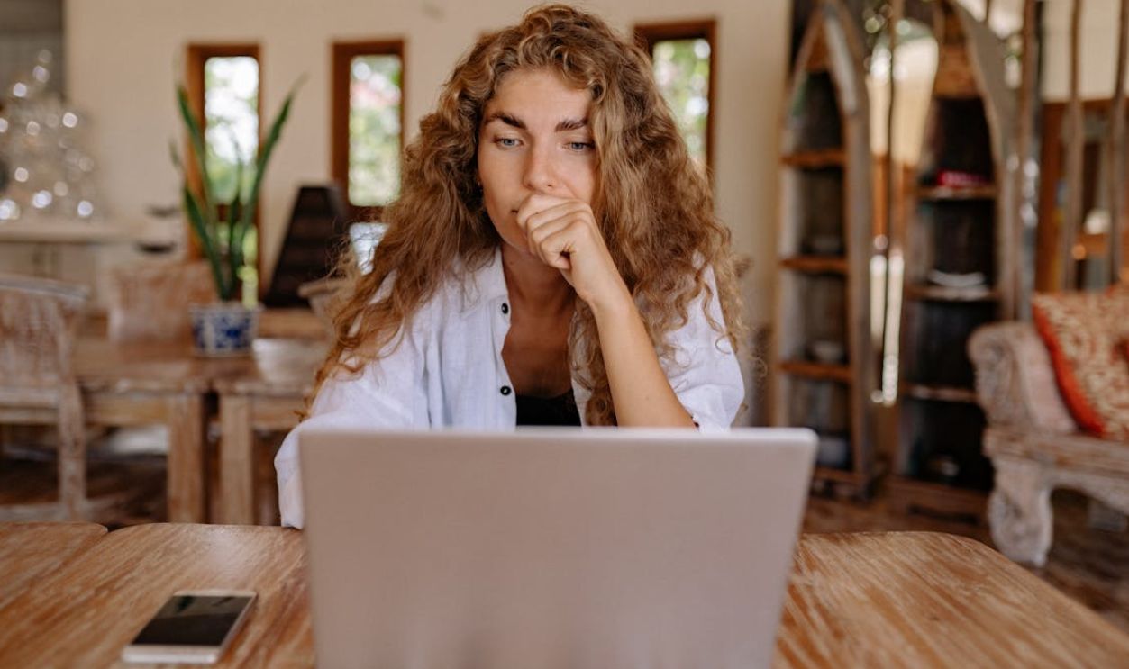 Woman in White Button Up Shirt While Using Laptop