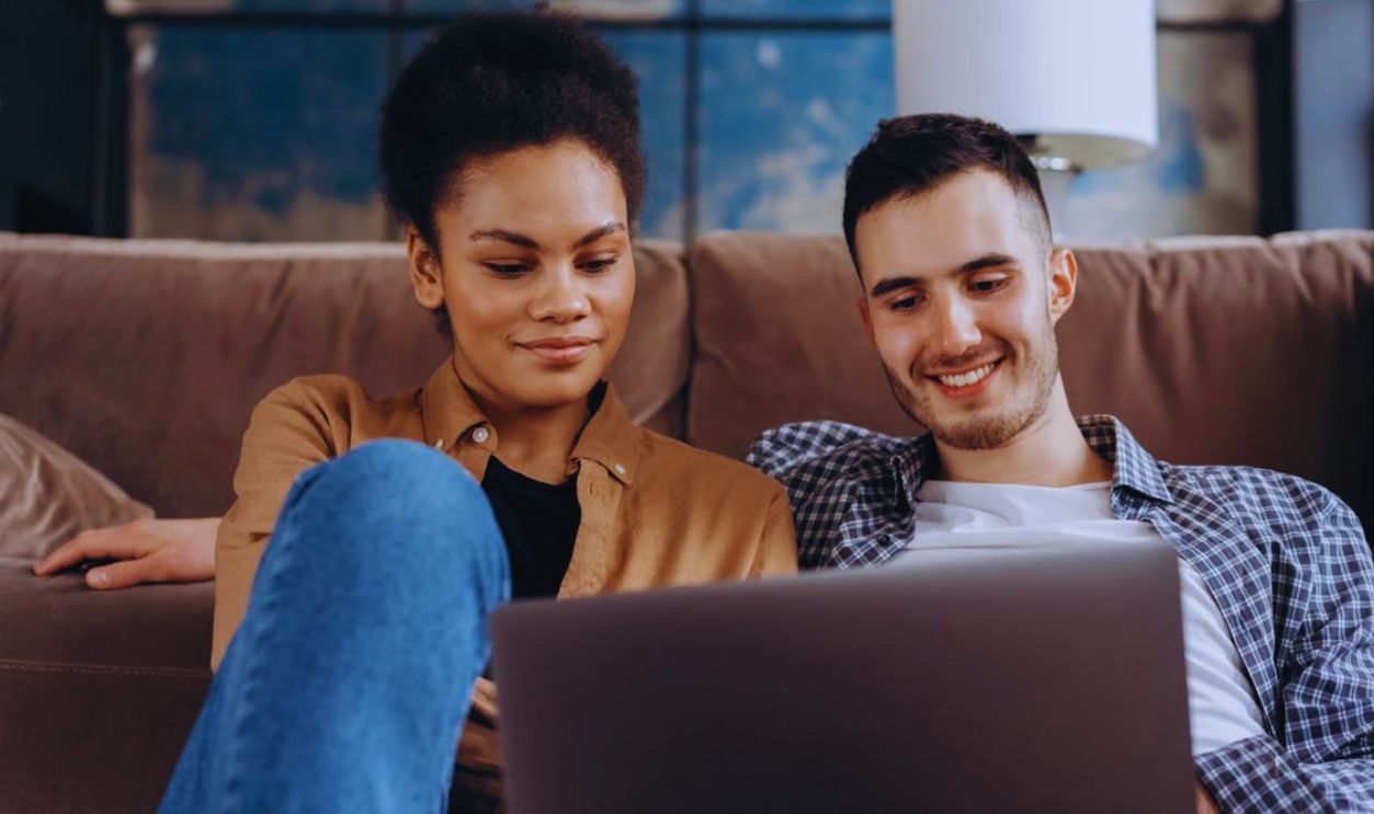Man and Woman Sitting on Floor Using Laptop