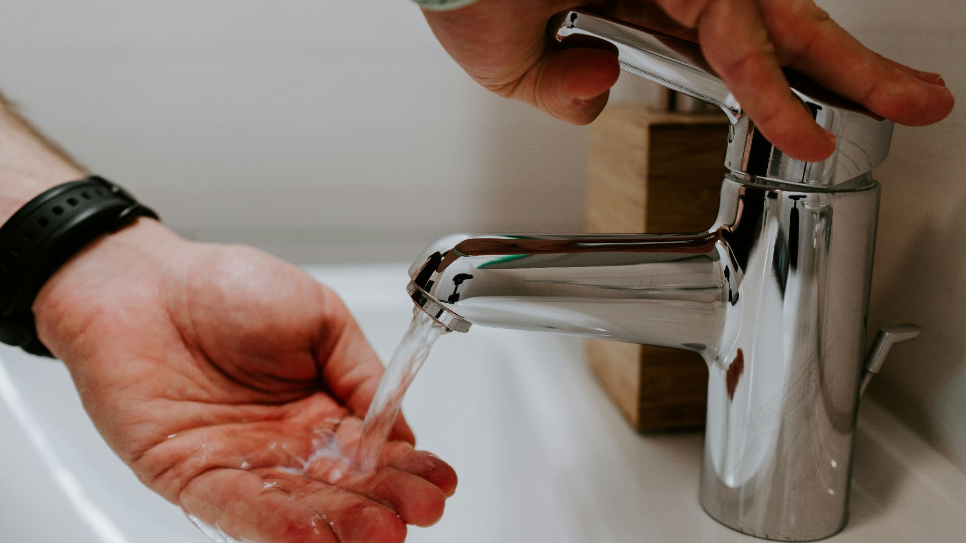 person holding stainless steel faucet