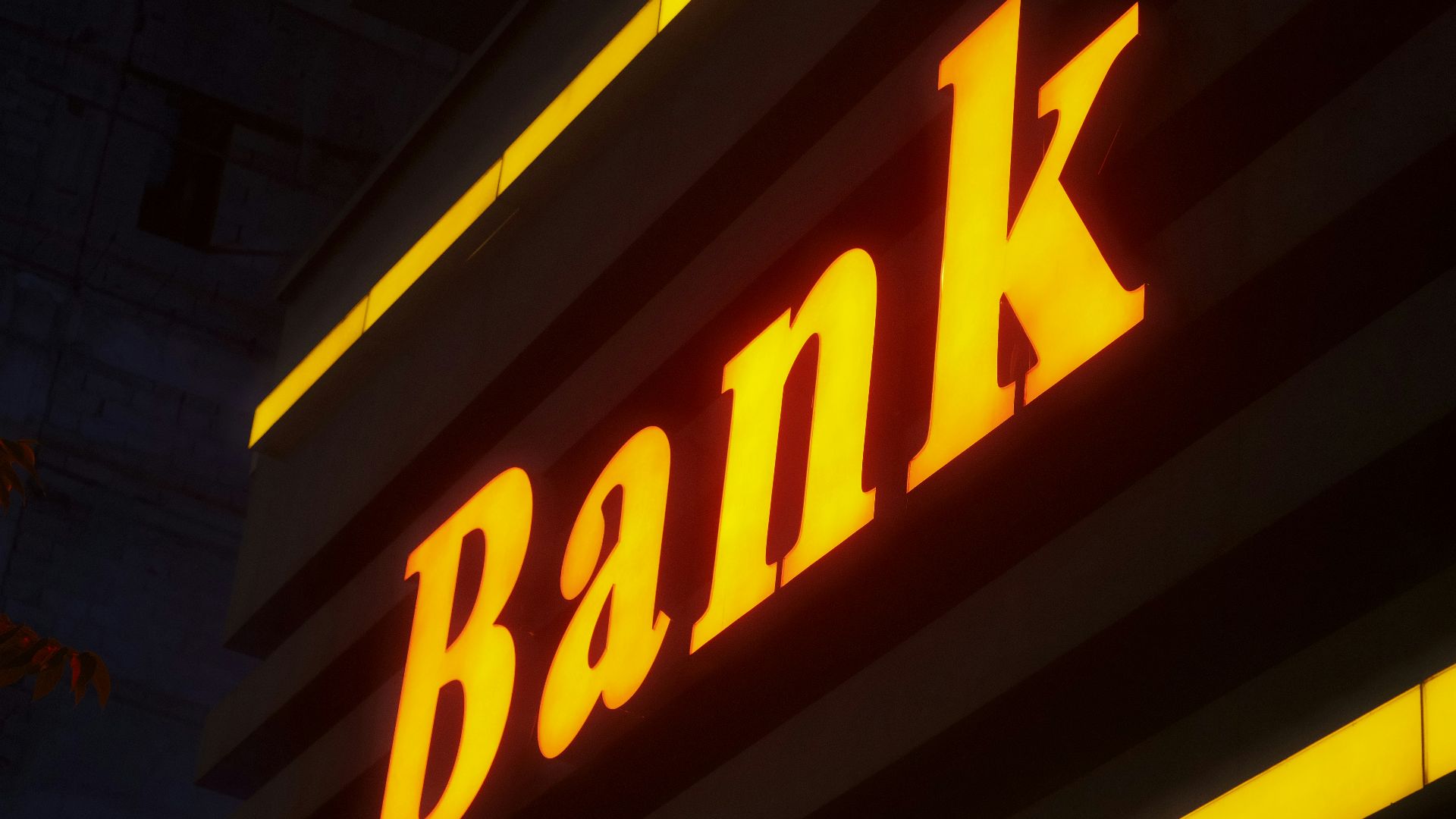 a bank sign lit up in the dark