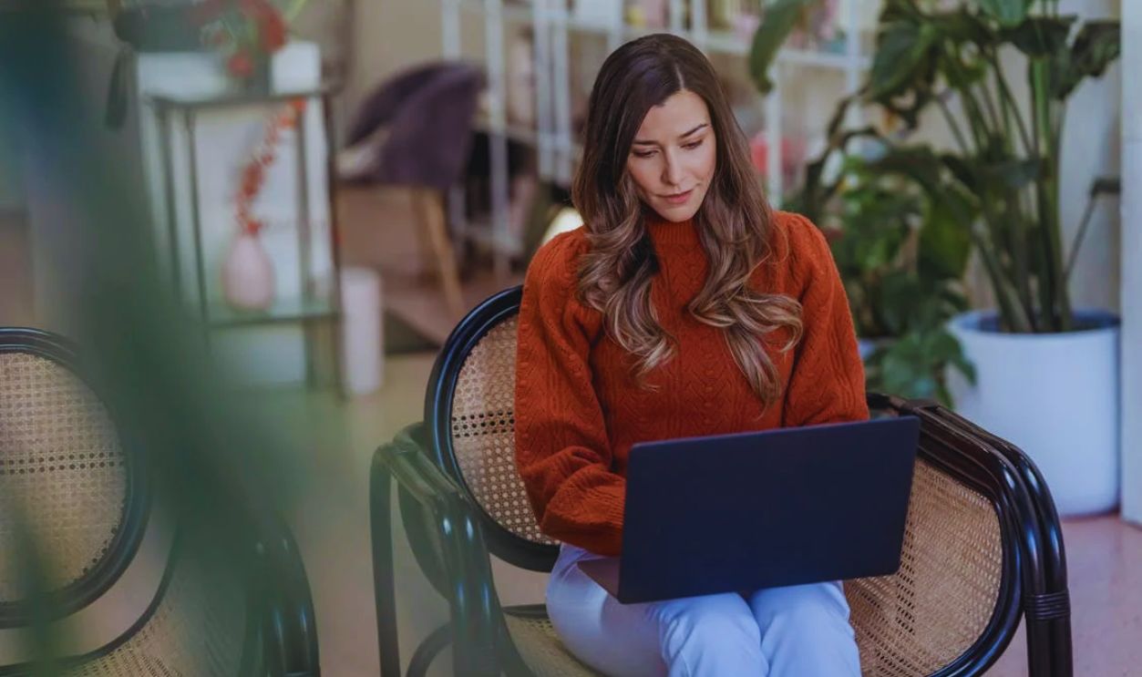 Serious female entrepreneur doing work on laptop