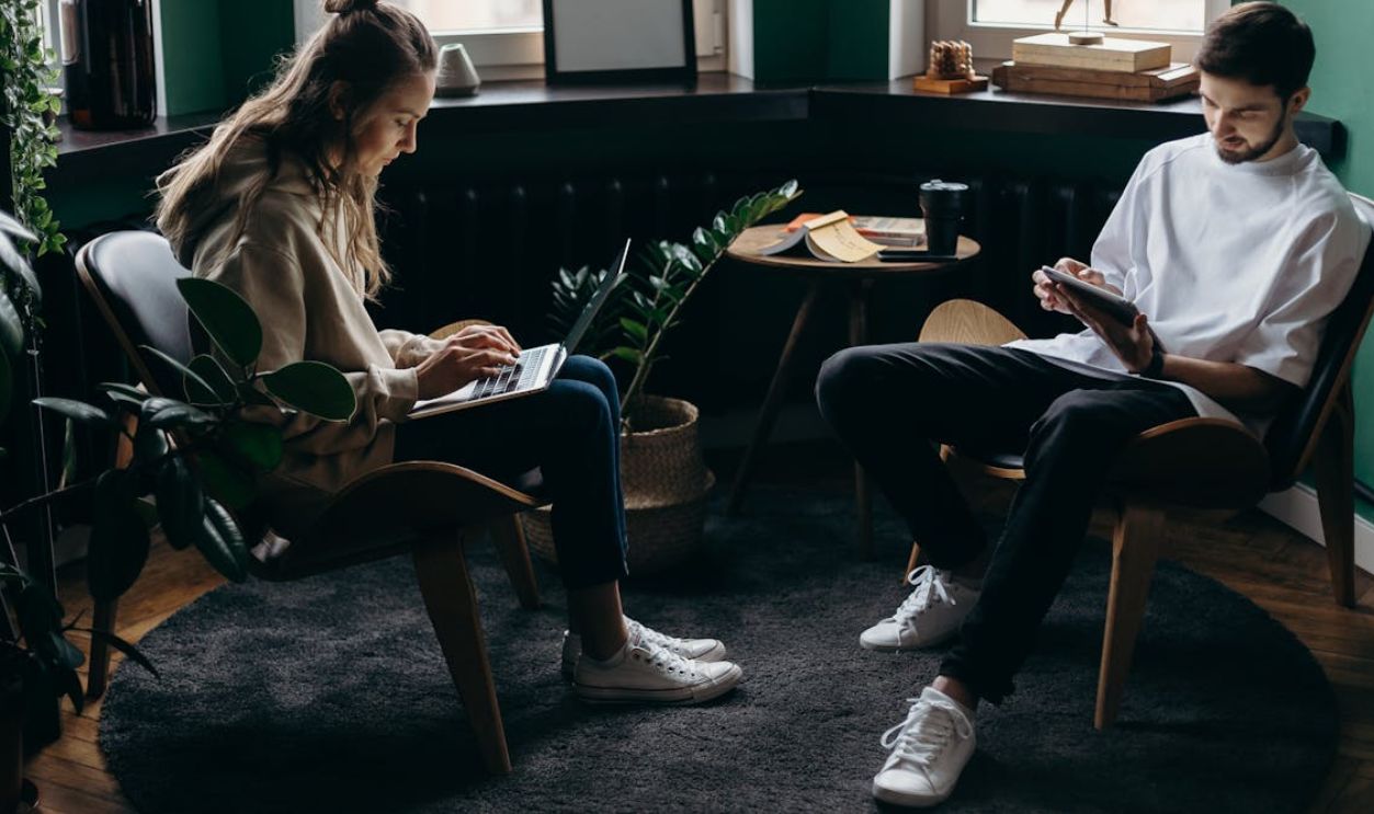 Photo of Two Person Using Their Gadgets