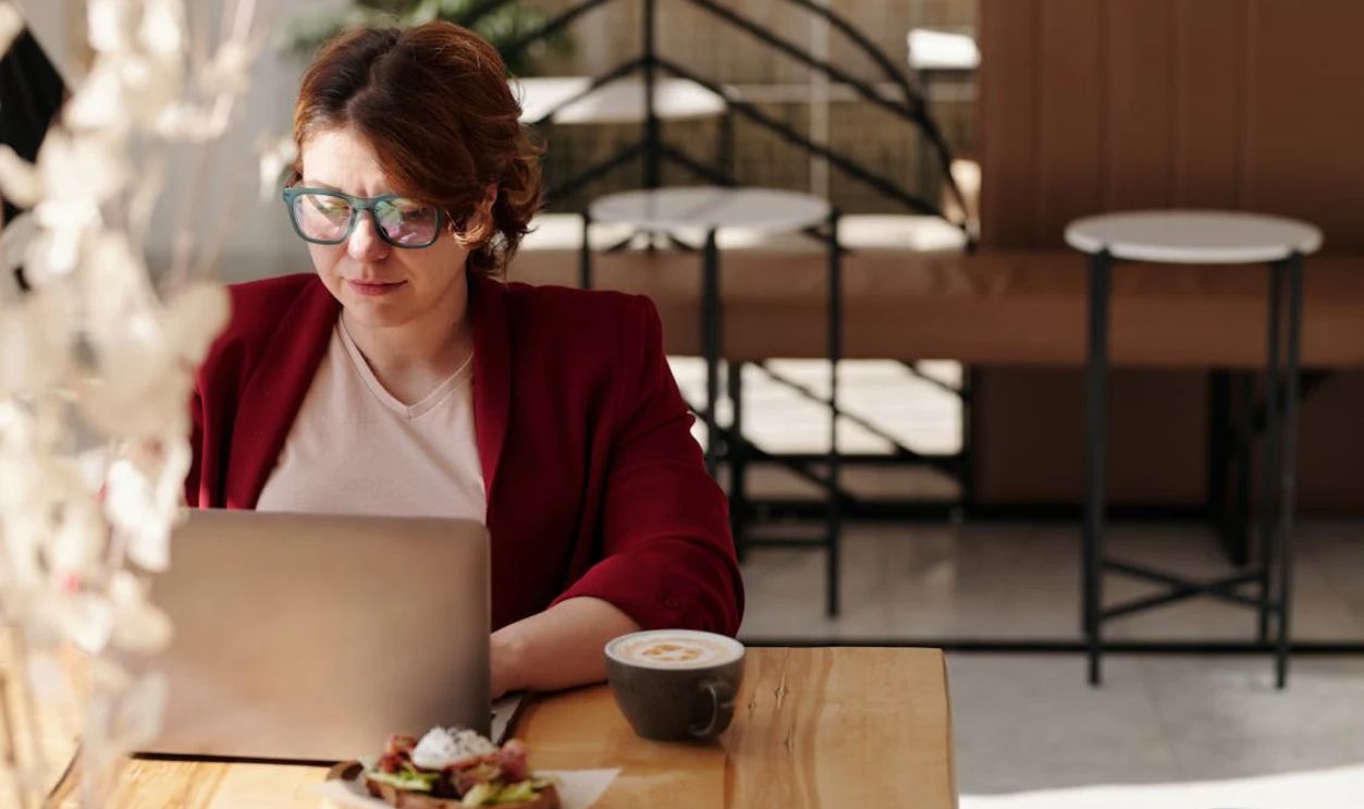 Woman in Red Blazer Using Laptop