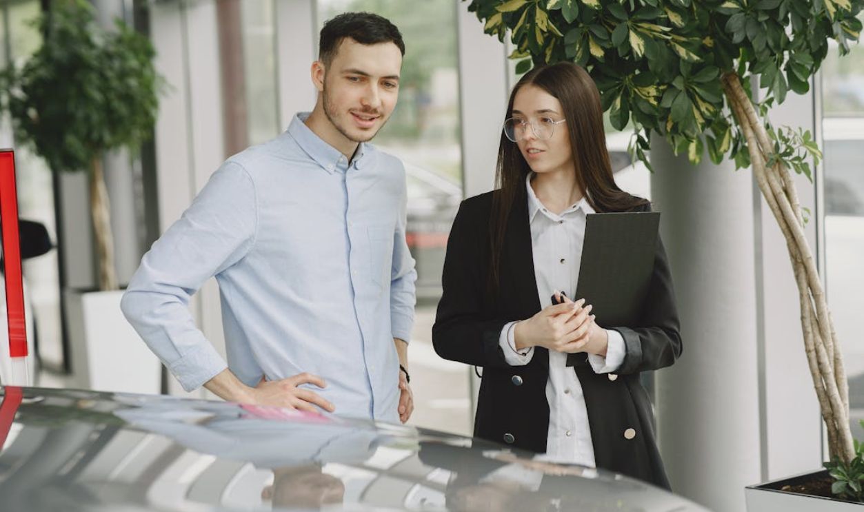 Man and Woman Looking at a Car