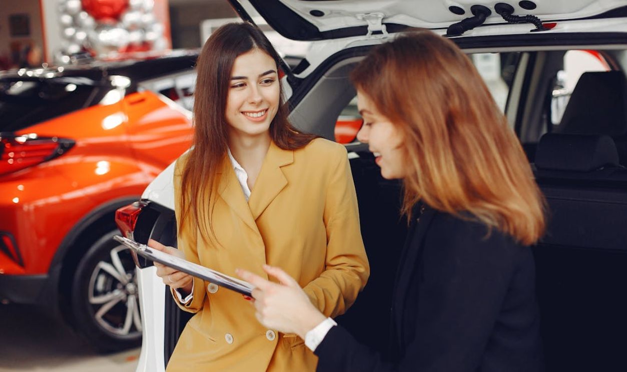 Friendly Car Dealer Showing the Contract to a Customer