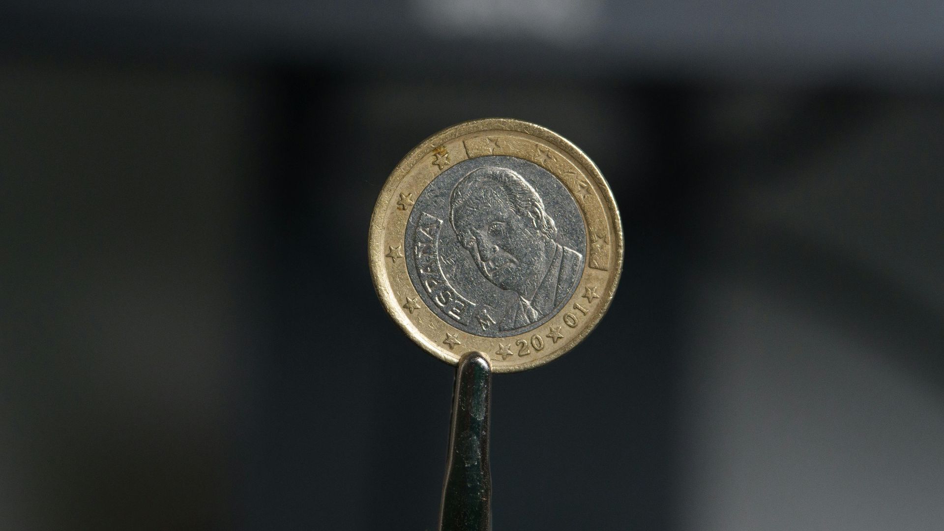 Detailed close-up of a 1 Euro coin featuring Miguel de Cervantes, in a studio setting.