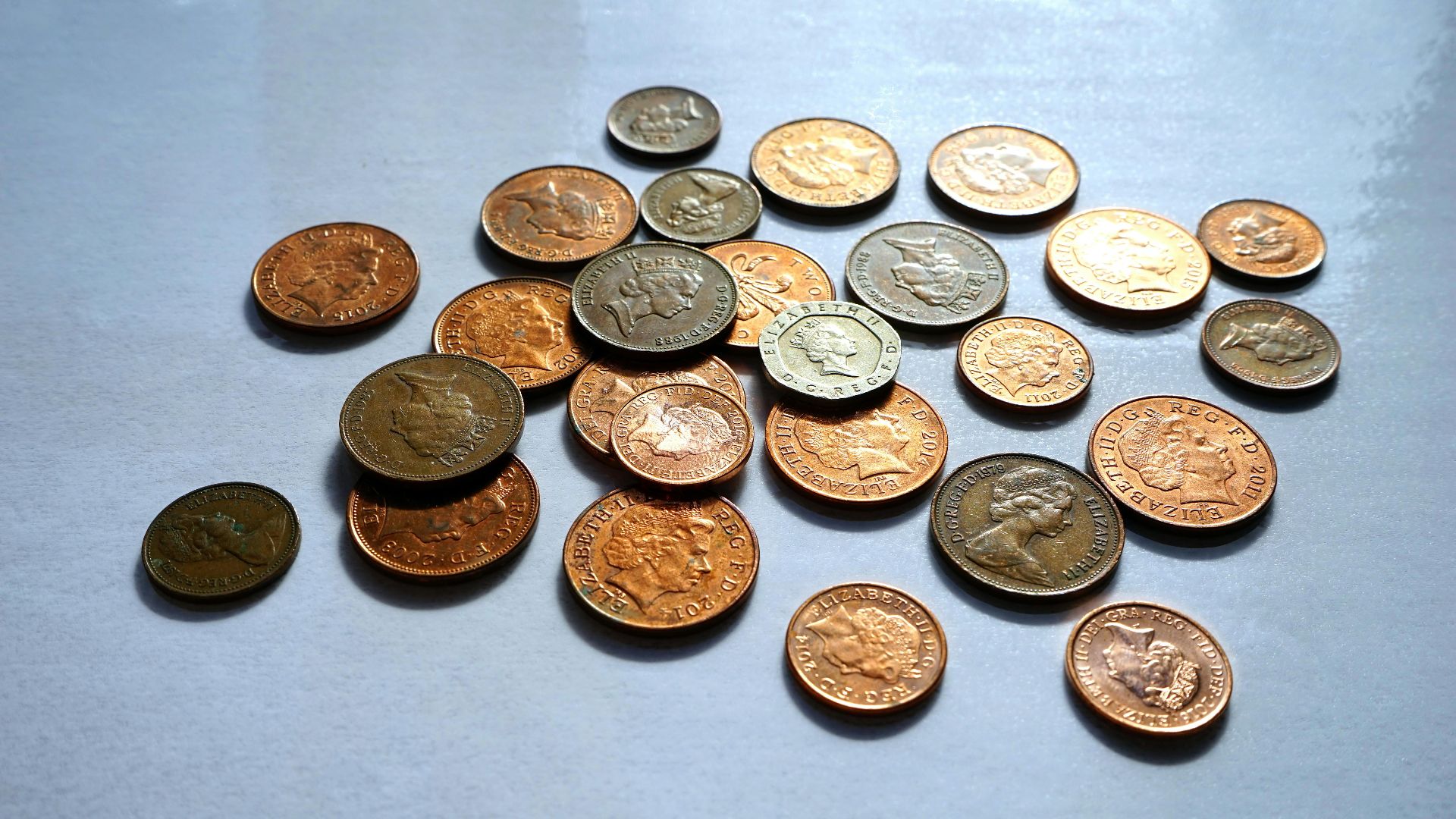Pile of assorted coins on a white background, ideal for finance themes.