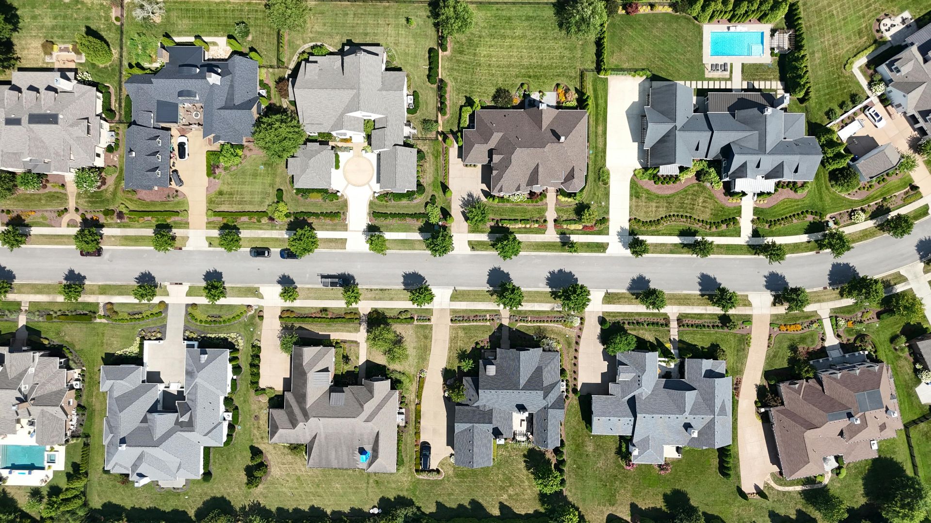 Overhead shot of beautiful homes in a suburban Tennessee neighborhood, showcasing lush greenery and modern architecture.