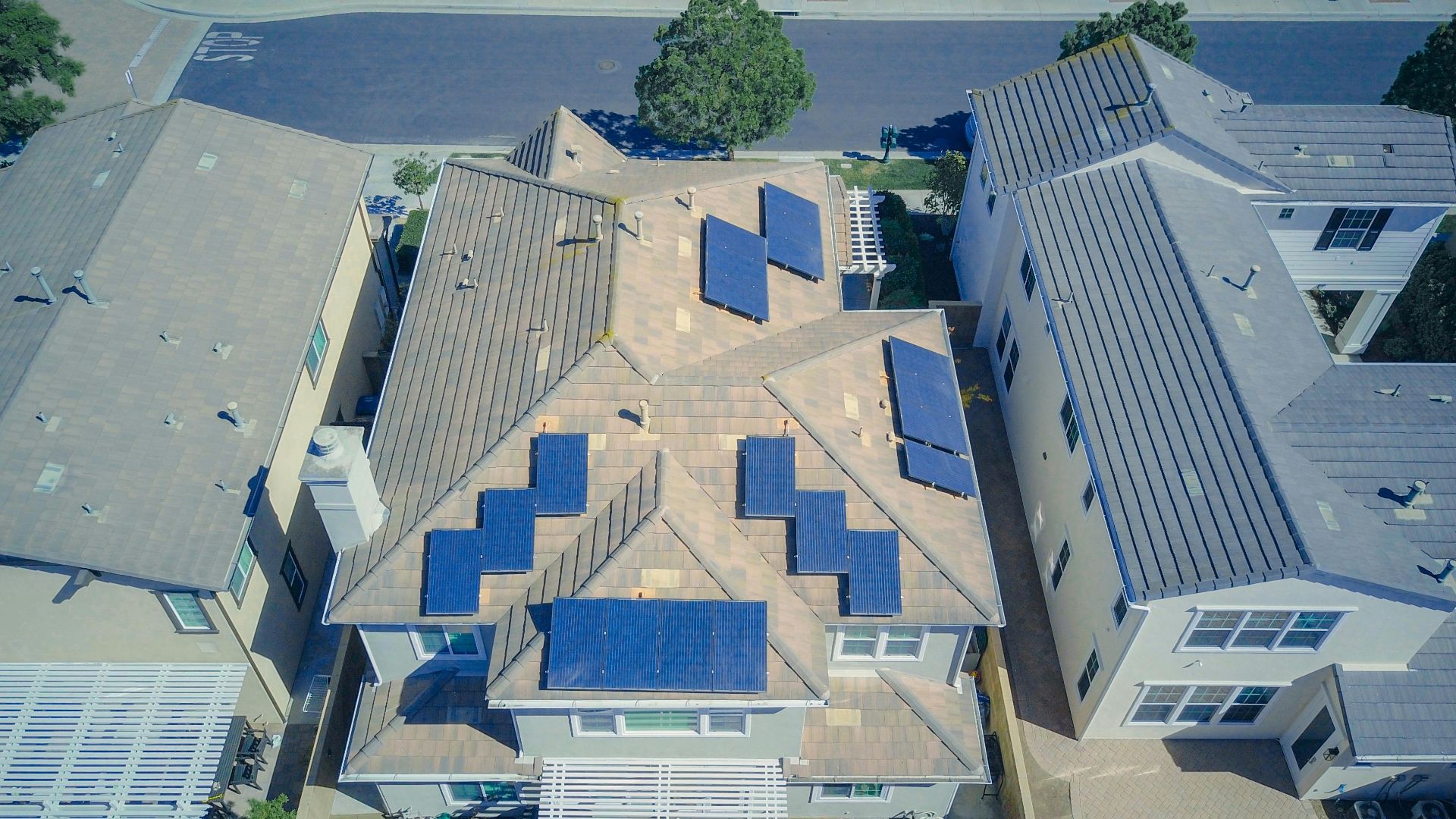 Aerial view of suburban homes equipped with solar panels in a sunny neighborhood.