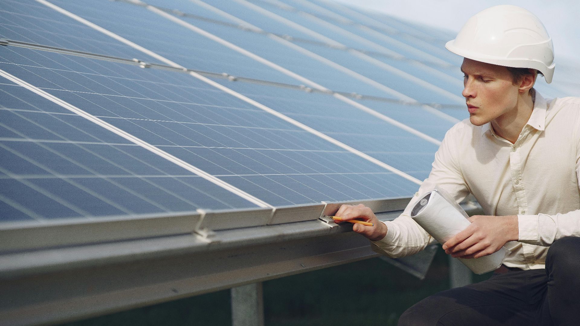 Engineer performing maintenance on solar panels for renewable energy sustainability.