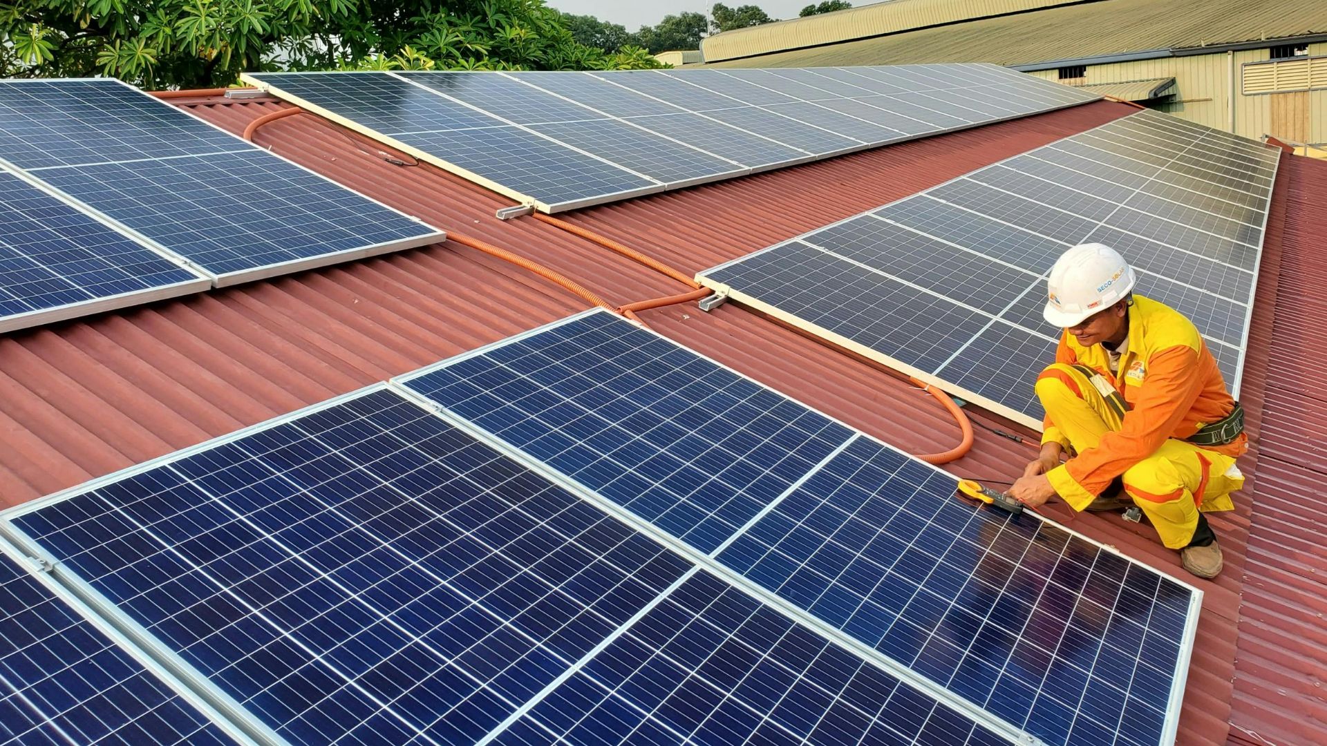 A solar technician performs maintenance on rooftop solar panels enhancing energy efficiency.