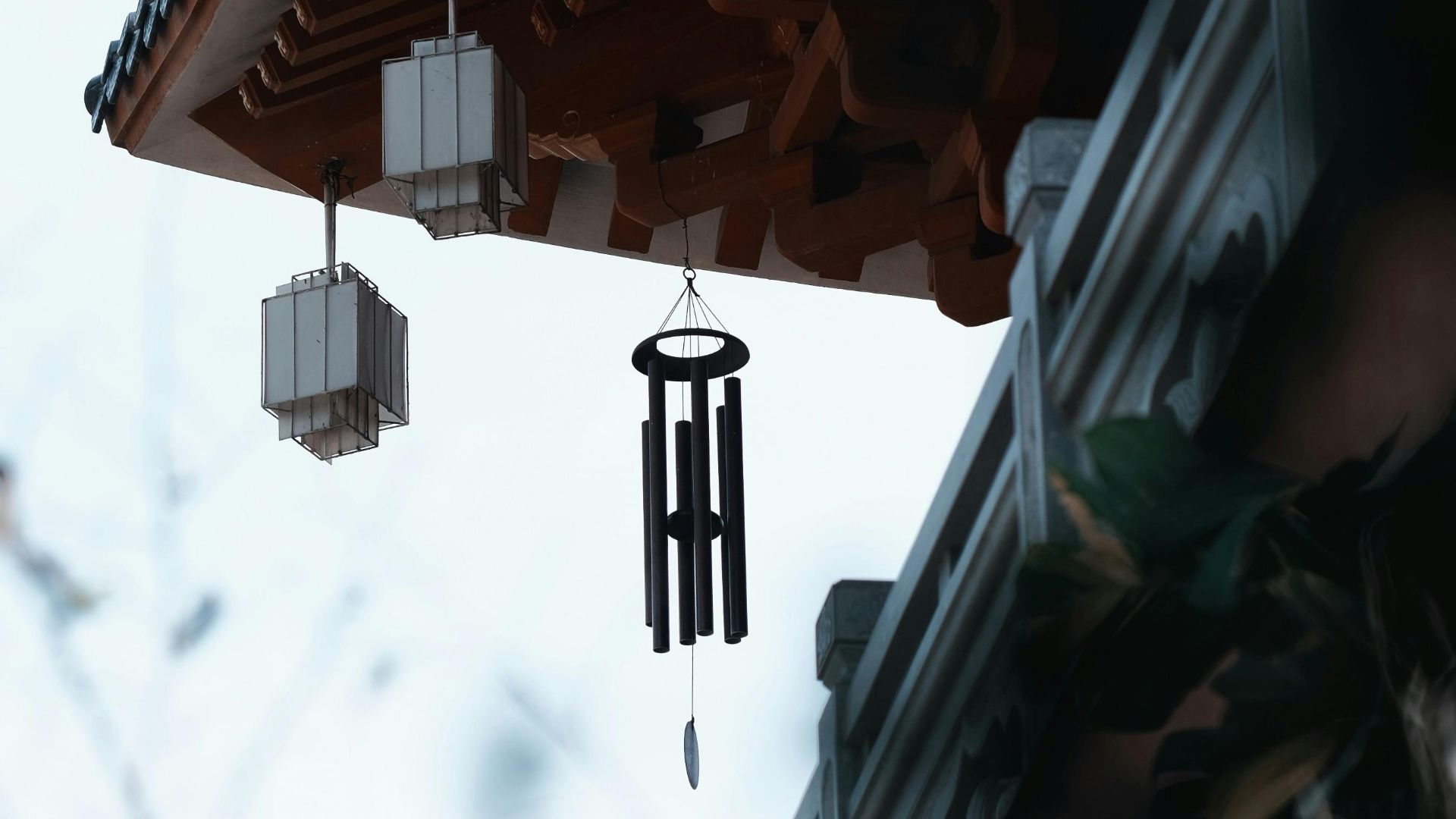 A serene view of a traditional Chinese pagoda roof adorned with wind chimes, evoking tranquility.