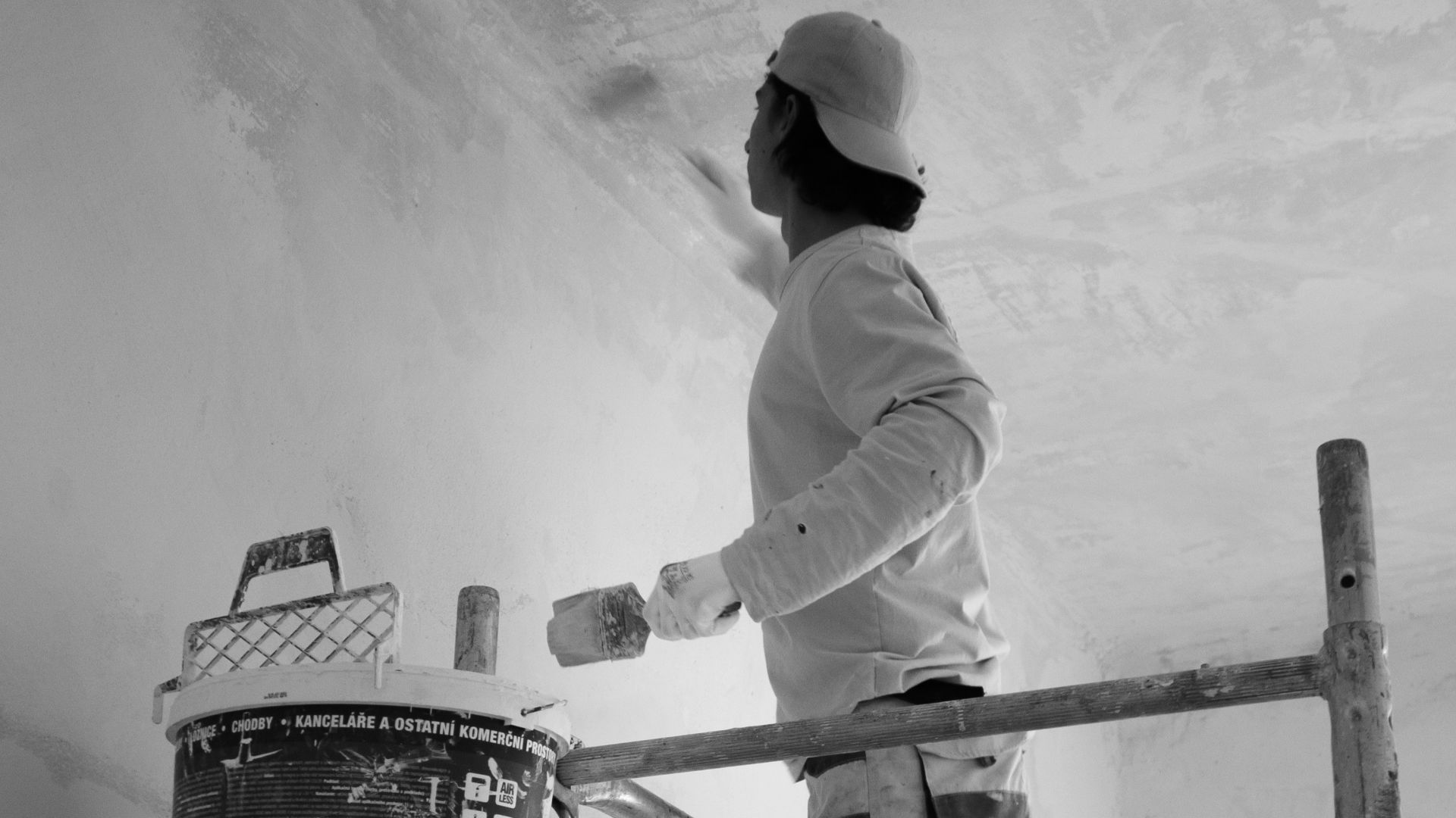 a man painting a wall with a paint roller