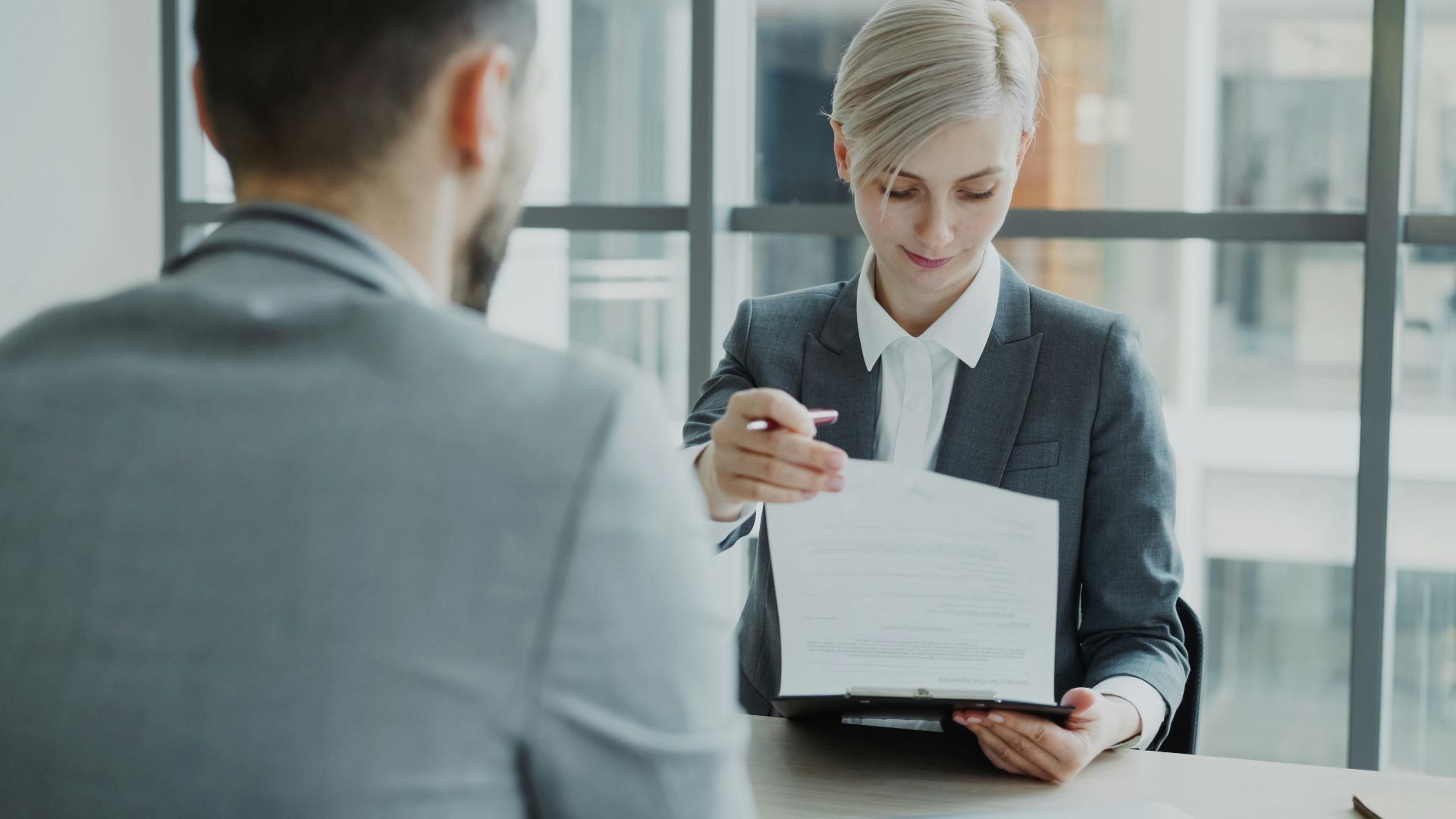 Woman in suit shows document to man