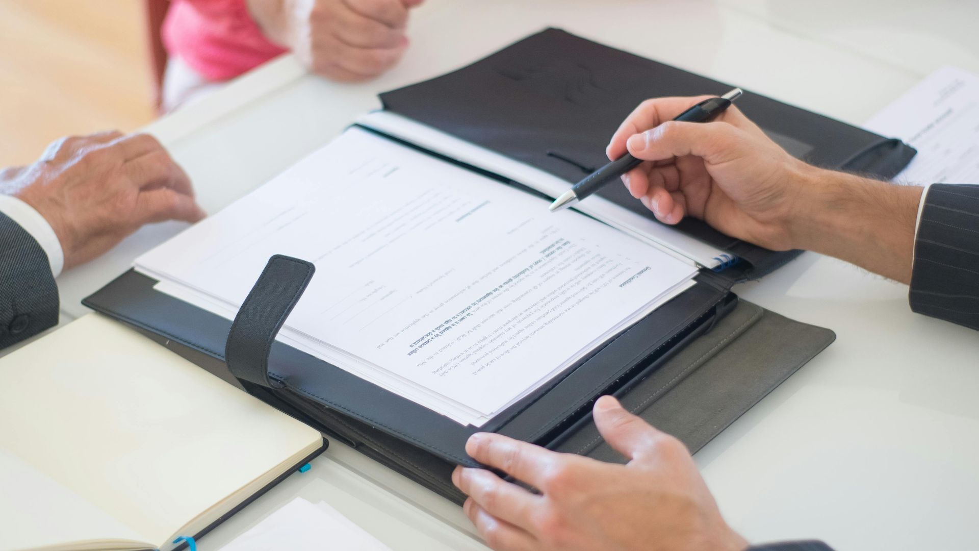 Senior couple and realtor discussing real estate contract at home office.