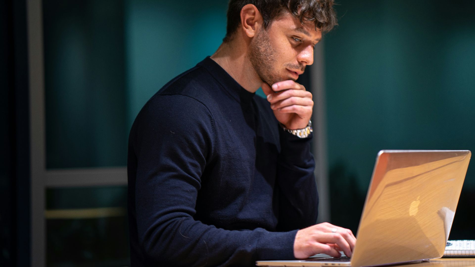 man in black long sleeve shirt sitting in front of macbook