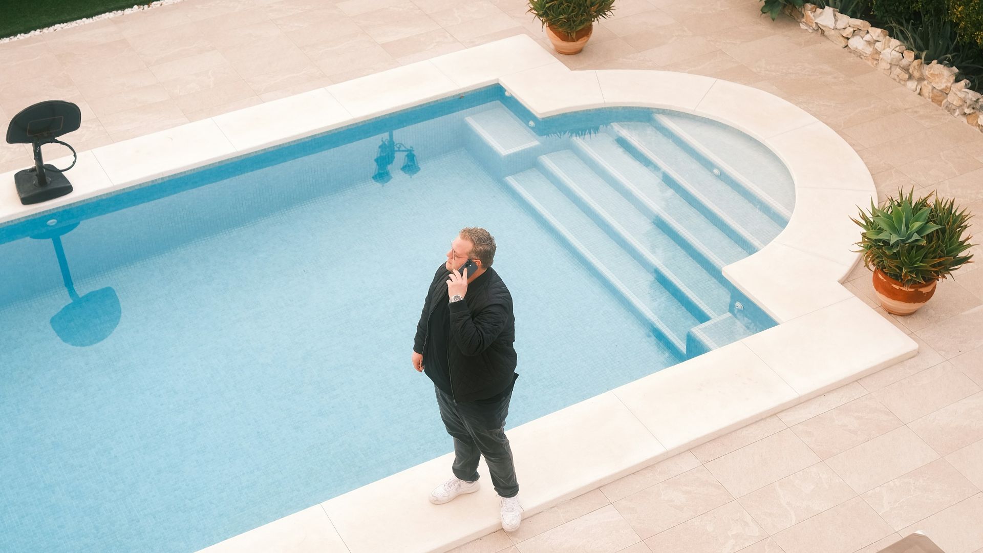 Man standing by a swimming pool with playground