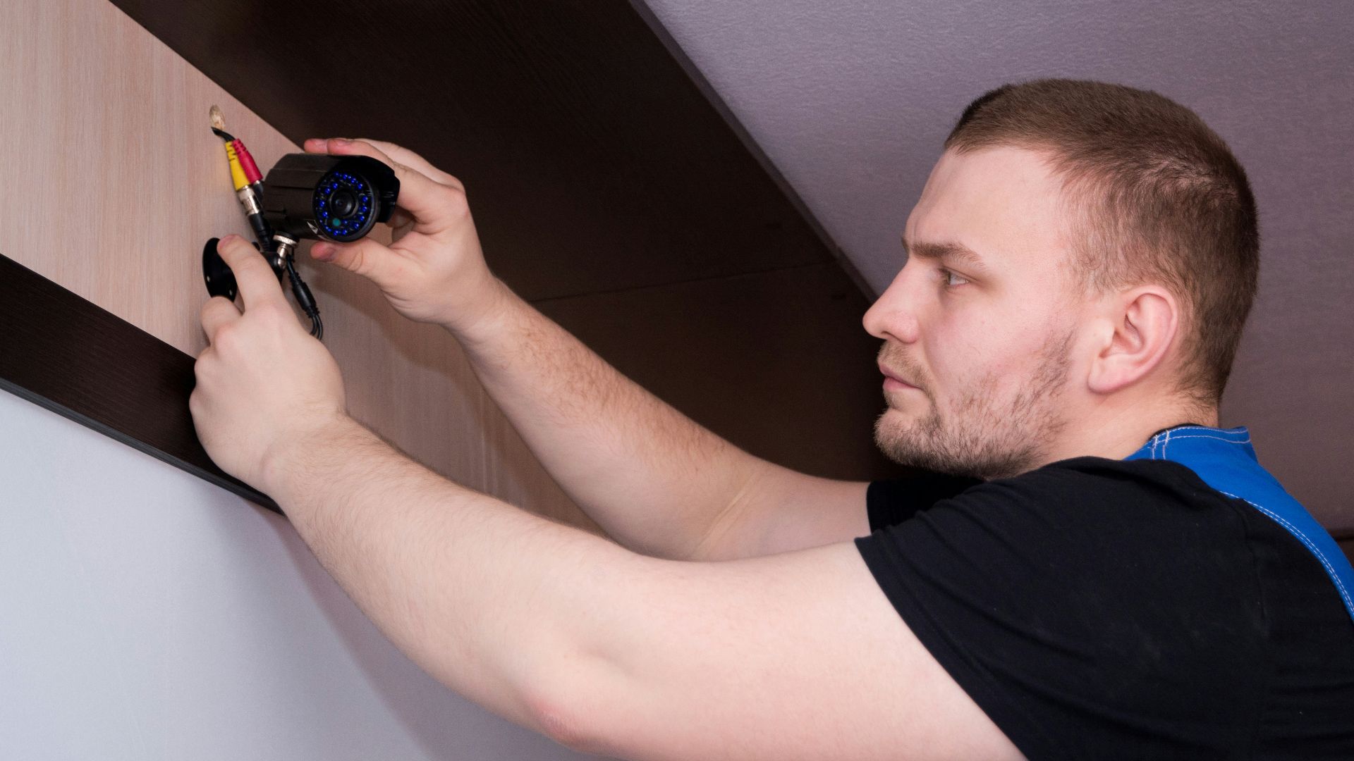 a man working on a wall with a screwdriver