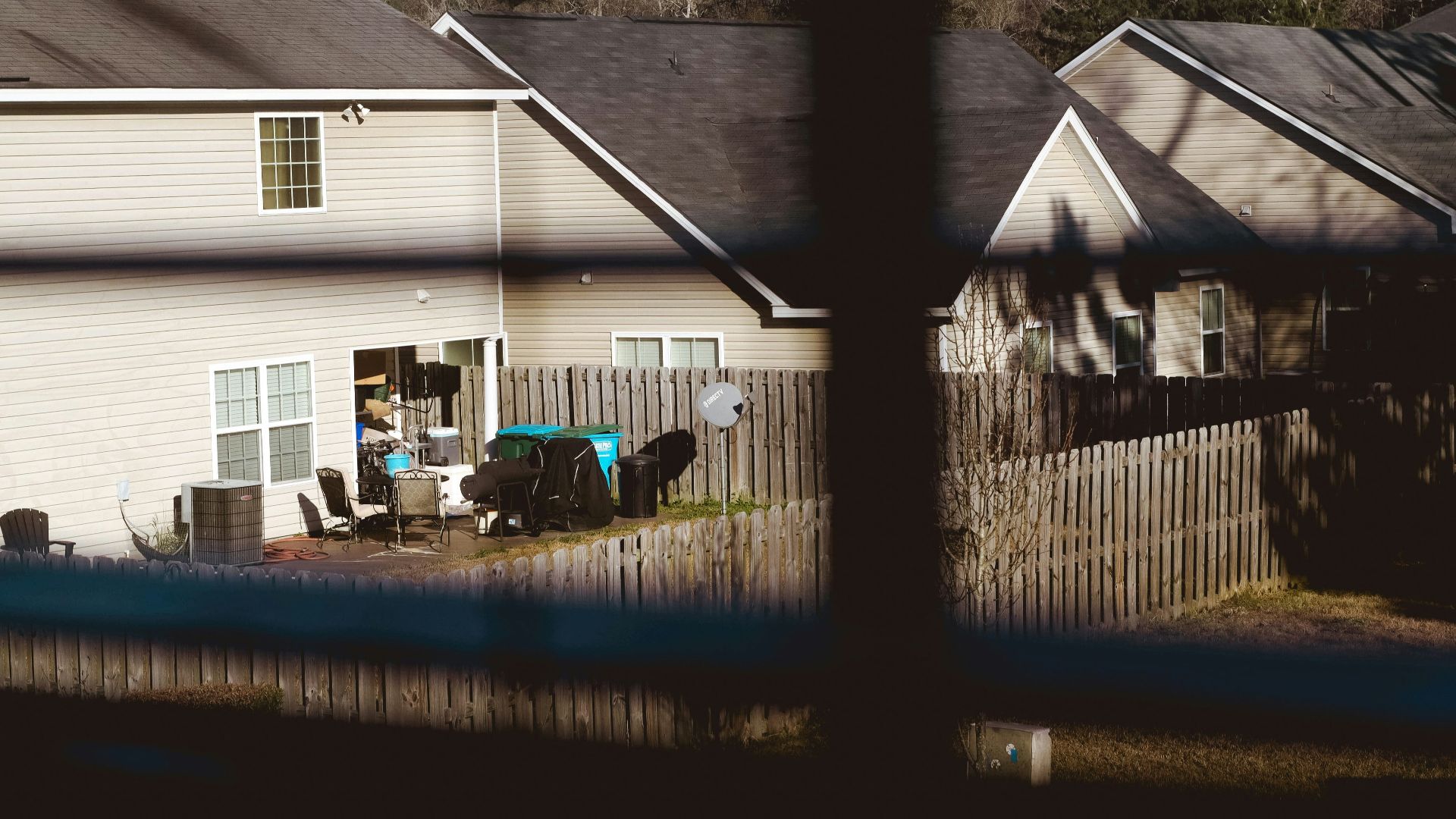 white and gray wooden house near green trees during daytime