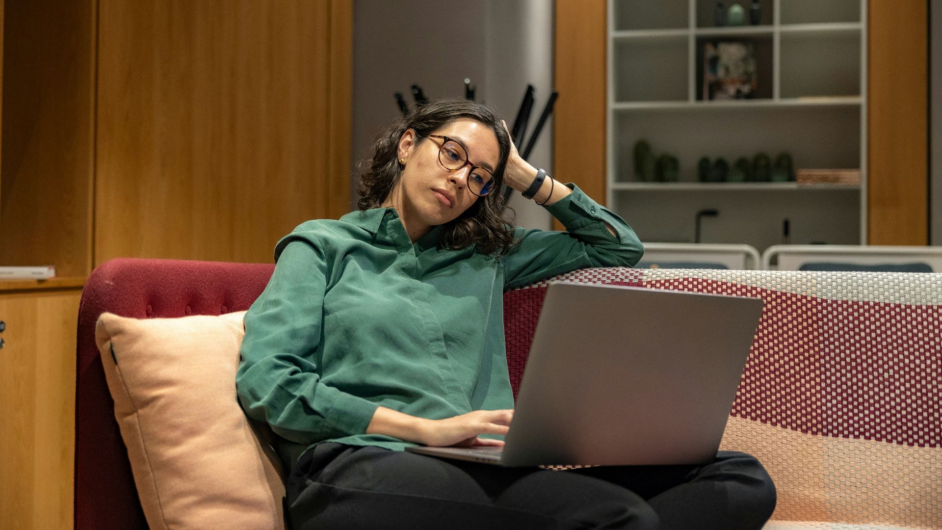 a woman sitting on a couch using a laptop computer