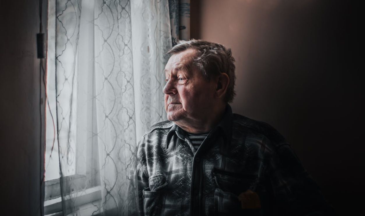Elderly Man By a Window Looking Outside