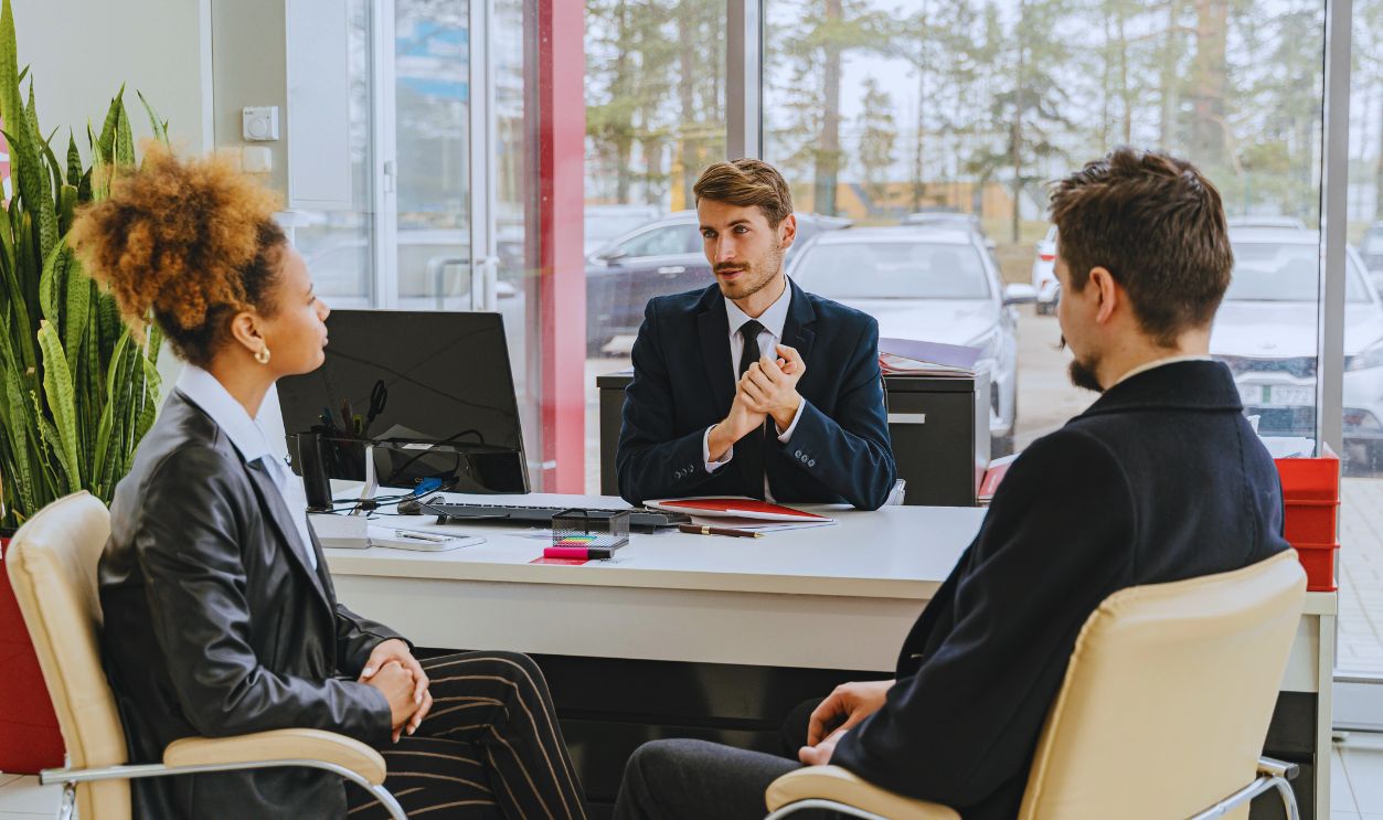 Man in a Suit Talking with a Couple in an Office