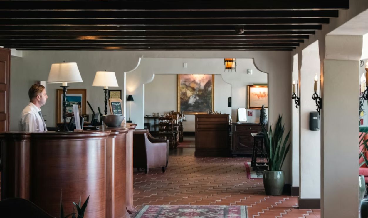 A woman is standing at the front desk of a restaurant
