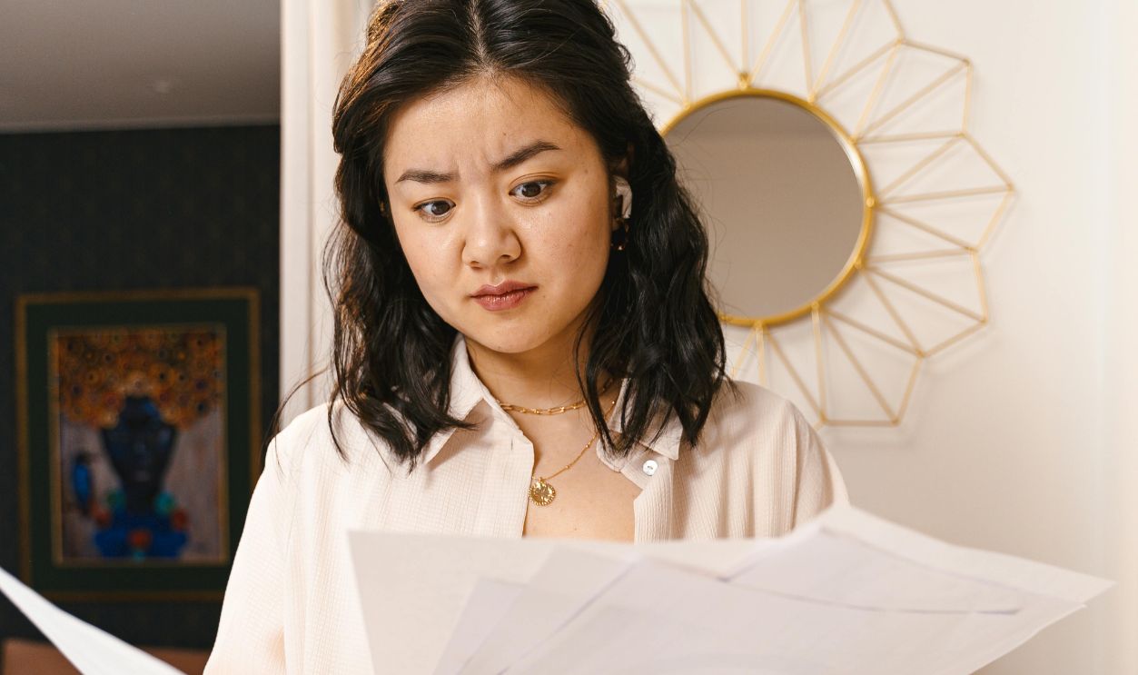 Confused Woman Looking at Papers
